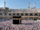 view of a crowd of praying Muslim pilgrims from all around the world revolving around the Kaaba