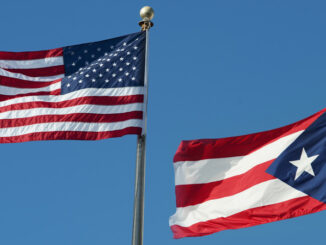 The United States flag and the Puerto Rico flag flying on flagpoles