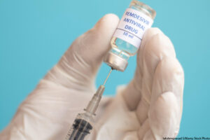 Close up of using a syringe to get Covid-19 vaccine from bottle