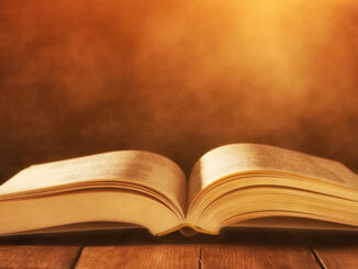 image of open book on wooden table with glitter background;