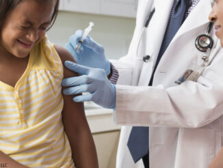 Young girl receiving medical injection in shoulder