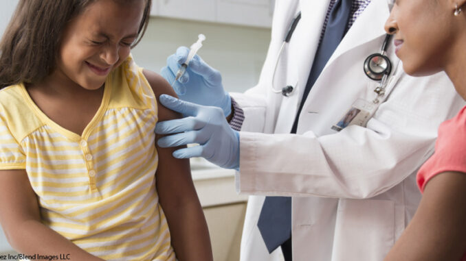 Mother comforting daughter with doctor injecting vaccine Young girl receiving medical injection in shoulder