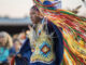 Native American woman performing grass dance in traditional attire