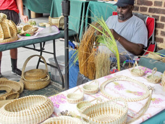 Gullah vendors making and selling sweetgrass baskets in Charleston City Market in Charleston, South Carolina