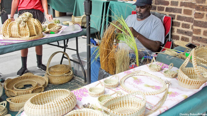 Gullah vendors making and selling sweetgrass baskets in Charleston City Market in Charleston, South Carolina Gullah vendors making and selling sweetgrass baskets in Charleston City Market in Charleston, South Carolina