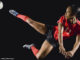 soccer player kicking soccer ball in mid-air