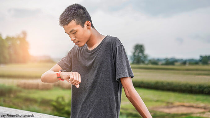 030722_03P_FS male teenager looking at watch checking running distance and heart rate