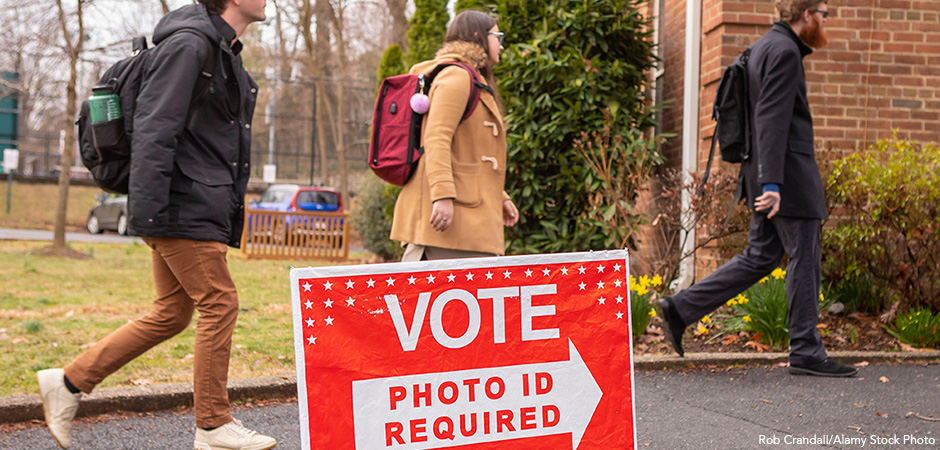 ARLINGTON, VIRGINIA, USA – MARCH 3, 2020: Democratic primary election voters arrive Lyon Village polling place. Photo ID sign.