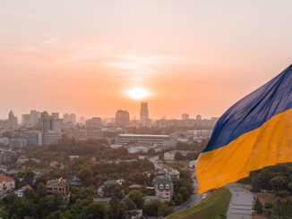 Aerial view of the Ukrainian flag waving in the wind against the city of Kyiv