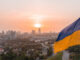 Aerial view of the Ukrainian flag waving in the wind against the city of Kyiv