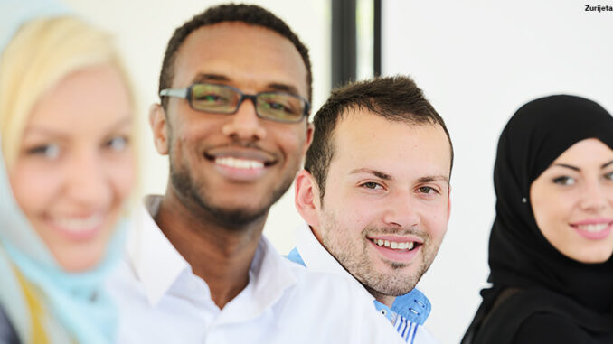 Arabic people having a business meeting, row with selective focus four multi-ethnic people in a row, smiling at the camera, two women in hijab