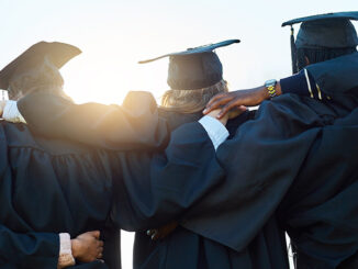 Rearview shot of a group of students standing in a row on graduation day