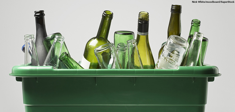 container filled with empty glass bottles against a white background