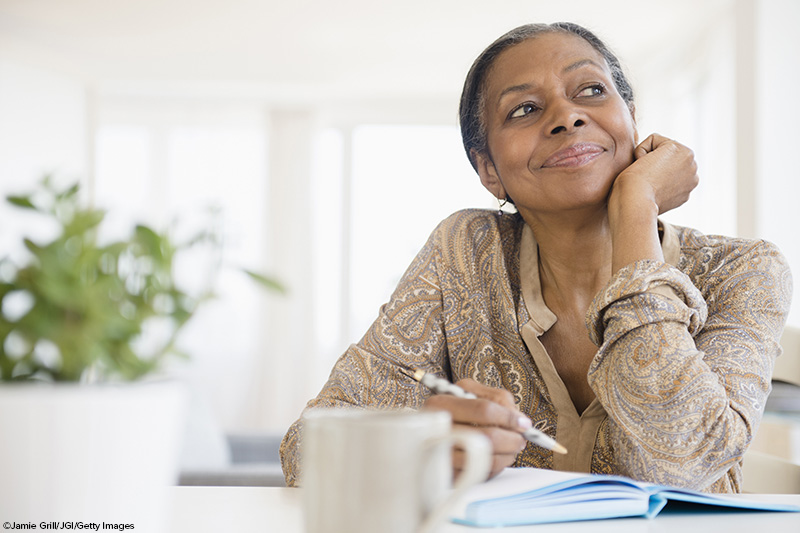 older woman writing at desk