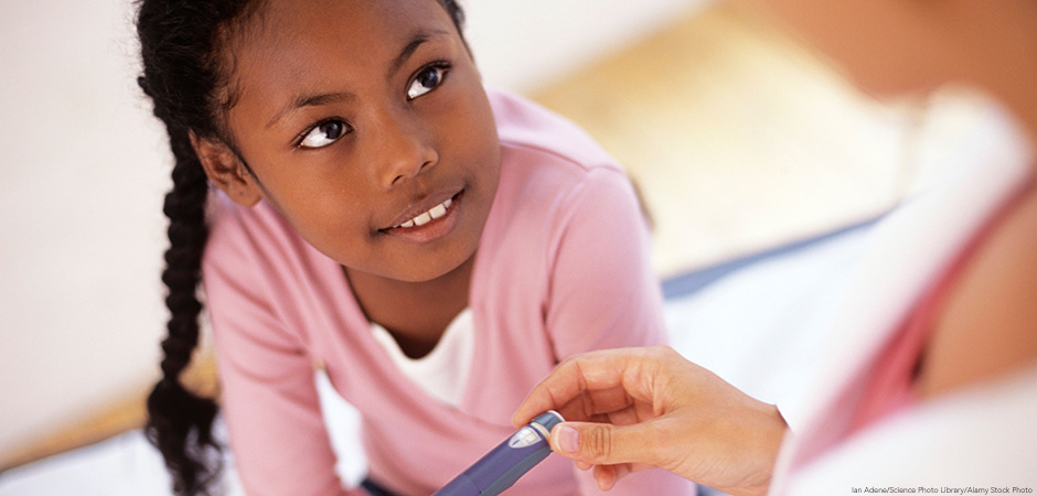 9-year- old girl listening to her doctor explain how to use an insulin syringe