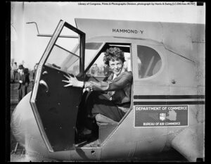 Amelia Earhart sitting in an airplane cockpit.