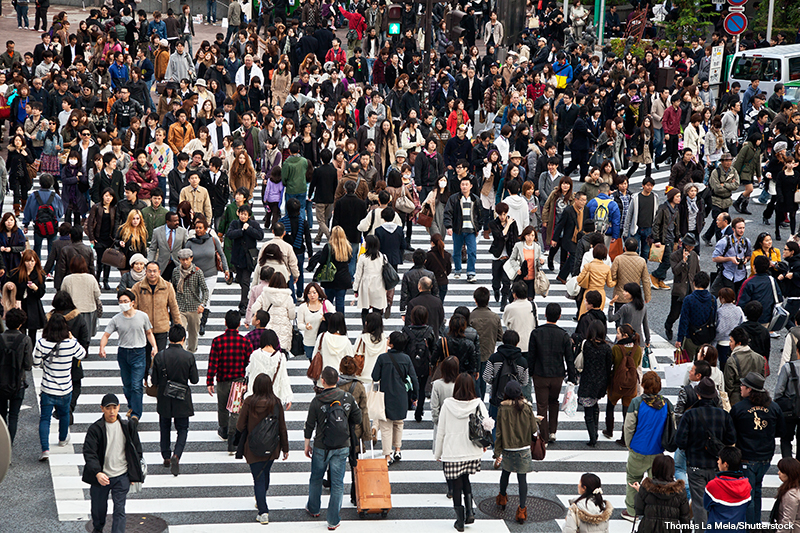 High-angle view of a large crowd of people crossing in multiple ways at a diagonal crossing, Hachikō Square, Shibuya, Tokyo, Japan