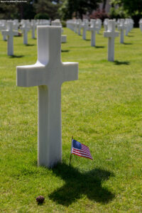 D-Day American Cemetery - White Cross tombstones with American flag at Coleville Cemetery, Omaha Beach, Normandy France