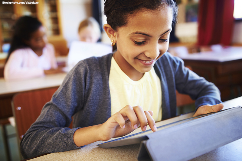 A middle school aged girl using a digital device in the classroom.