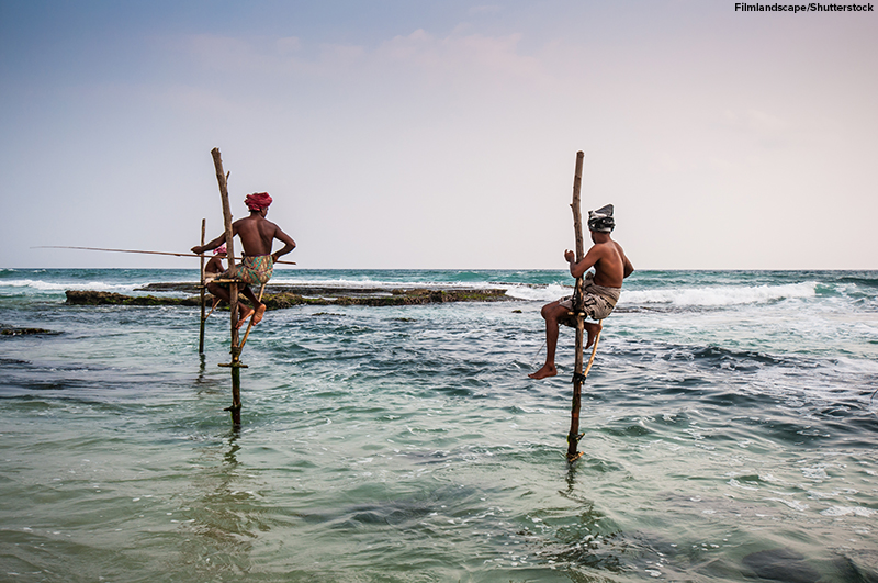 Traditional fishermen on stilts, fishing in the ocean, Koggala, Ahangama, Sri Lanka.