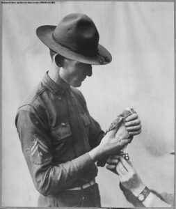 Attaching a message to a Signal Corps carrier pigeon, circa 1917-18