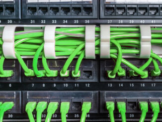 Server rack with green internet patch cord cables connected to patch panel in server room
