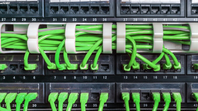 Server rack with green cables Server rack with green internet patch cord cables connected to patch panel in server room