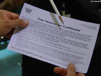 Close-up of a 2010 Census interviewer reviews a confidentiality notice with a household resident.