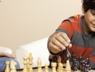 young boy playing chess with an adult