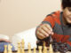 young boy playing chess with an adult
