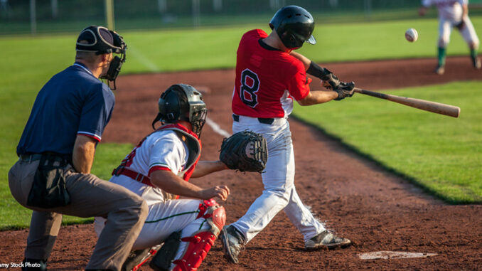 Batter, catcher, and umpire at home plate on a baseball field.