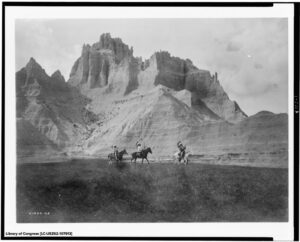 Black and white photo of Native Americans riding in the South Dakota Badlands.