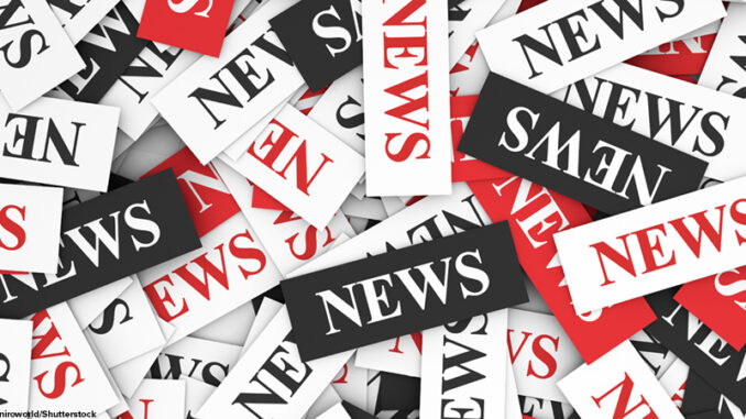 News concept background with a multitude of sign and text on scattered paper.