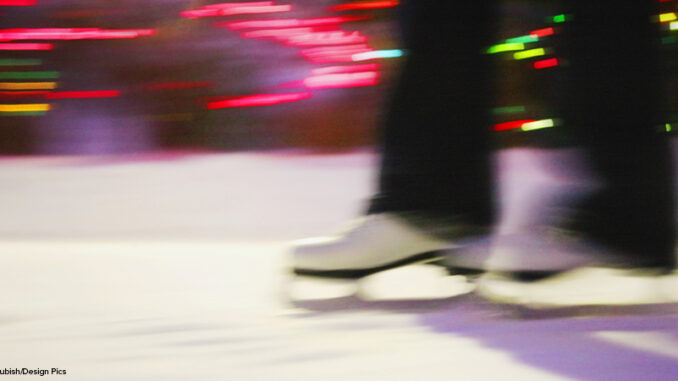 close up blurred shot of figure skating boots on ice