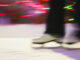 close up blurred shot of figure skating boots on ice